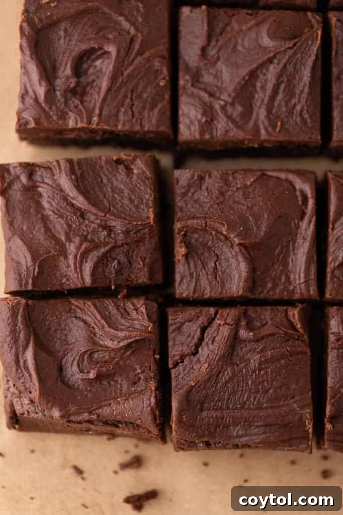 The 4-Minute Frosting Hack for Brownies 2 Perfectly cut squares of frosted brownies, neatly lined up on a serving tray, showcasing the thick chocolate frosting.