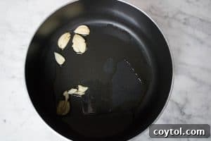 Sautéing garlic to infuse the olive oil with flavor for the marinara sauce