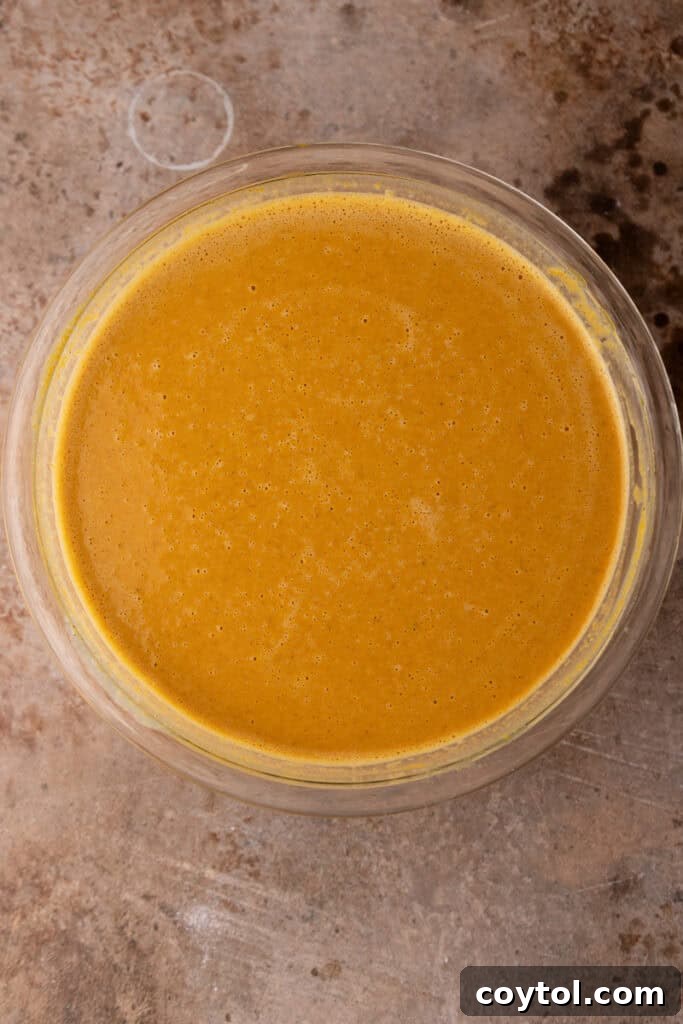 The smooth pumpkin pie filling in a bowl, ready to be poured