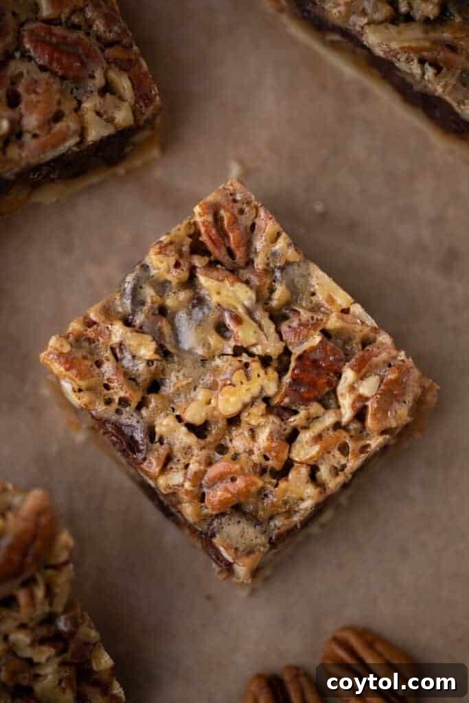 close up of a single chocolate pecan pie bar, showing the crust, filling, and chocolate chips