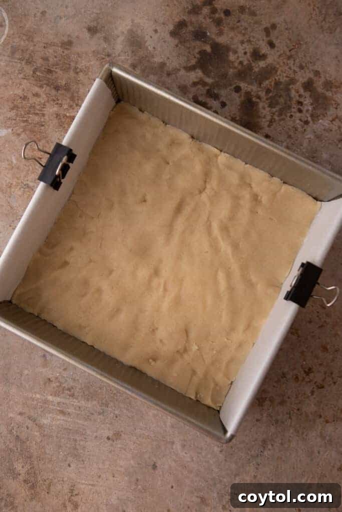 raw shortbread dough pressed into the bottom of a baking dish