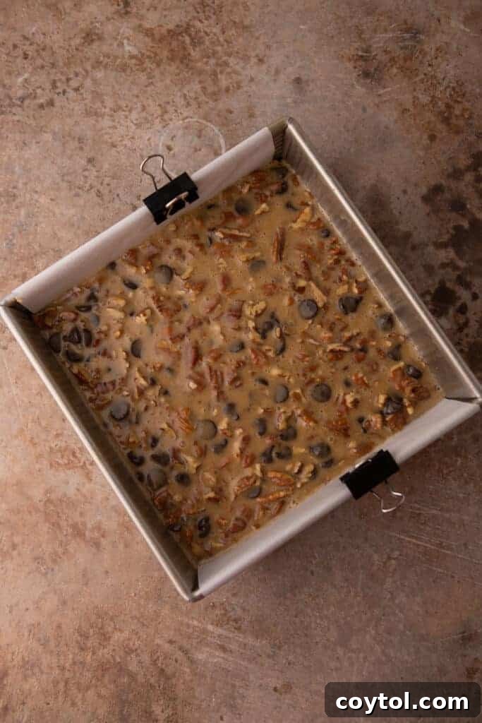raw chocolate pecan pie bars in the baking dish, ready for the oven