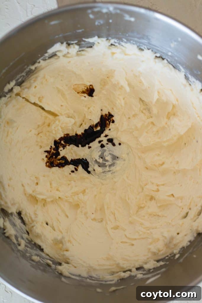 Adding the cooled instant coffee mixture to the buttercream.