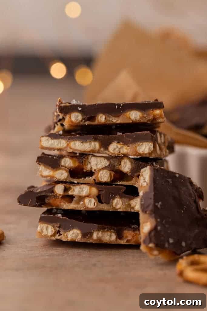 Stack of chocolate caramel pretzel crack pieces with visible pretzels and chocolate layers. Delicious sweet and salty holiday treat.