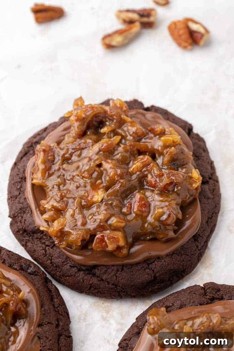 A tantalizing Crumbl German Chocolate Cake Cookie, topped with a rich pecan coconut frosting.