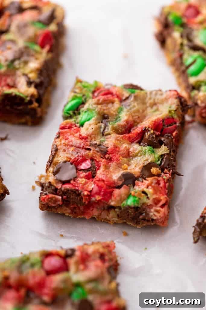 Close-up of a festive Christmas Magic Cookie Bar with chocolate and M&M's
