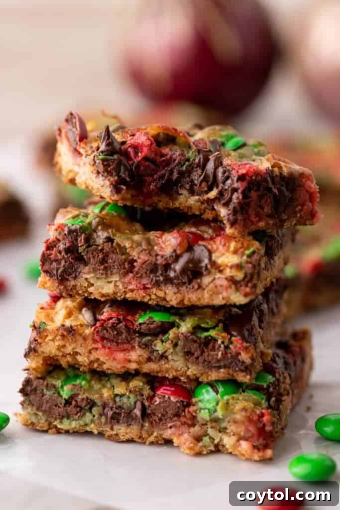 A stack of golden Christmas Magic Cookie Bars, showing off their rich layers