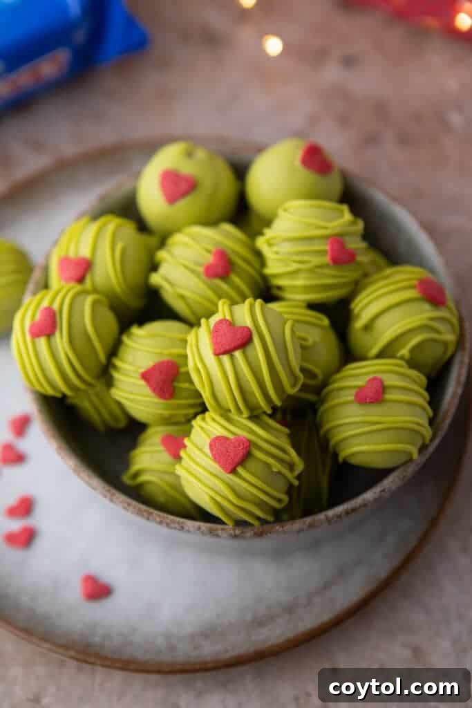 grinch oreo truffles in a bowl, showcasing their vibrant green and red colors