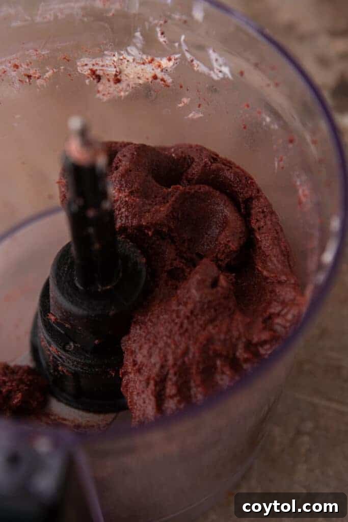 oreo and cream cheese being blended together in a food processor, forming a dough