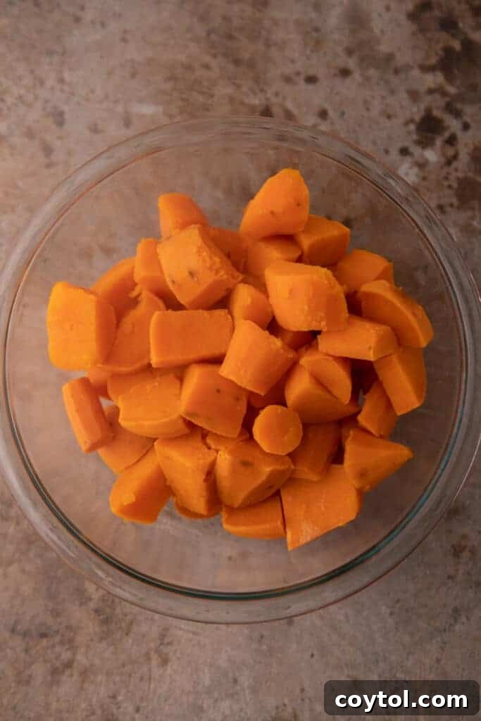 A bowl filled with fully boiled and tender sweet potatoes, ready for mashing.