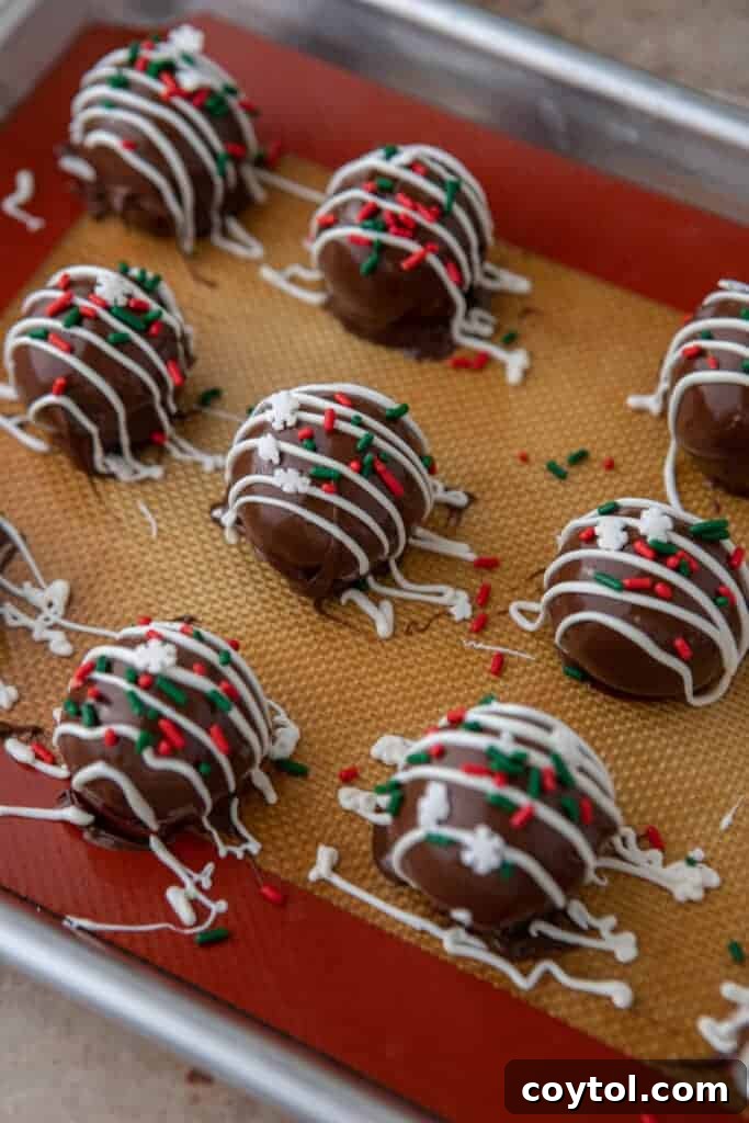 multiple finished Little Debbie Chocolate Christmas tree cakes truffles lined up on a baking sheet