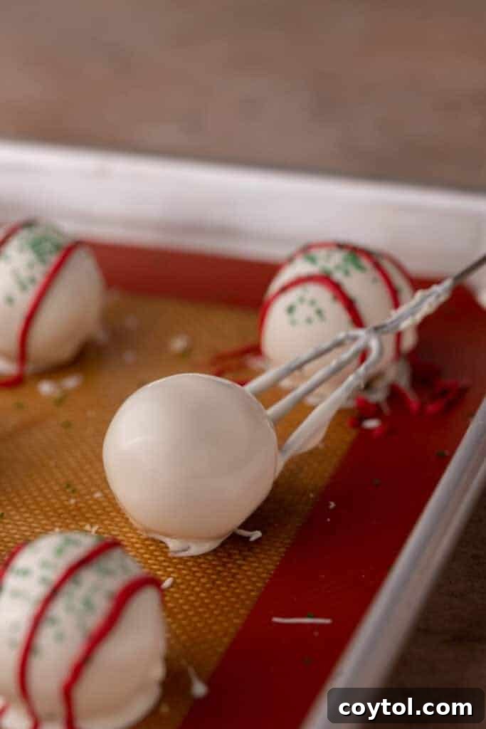 Whip Up Little Debbie Christmas Tree Cake Truffles No Baking Required 9 dipped ball being put on a baking sheet