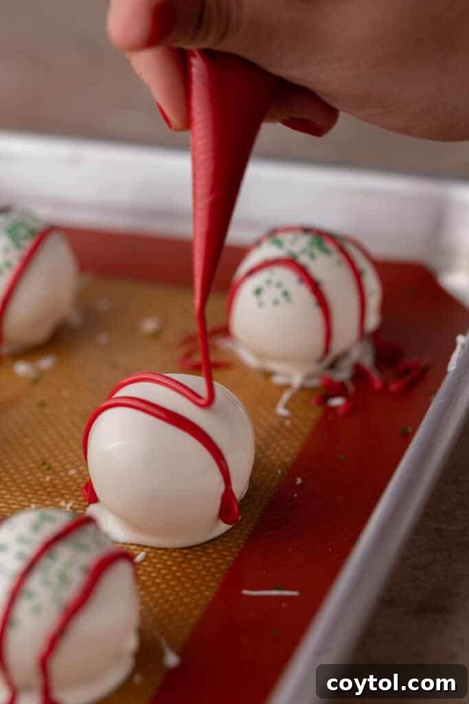 Whip Up Little Debbie Christmas Tree Cake Truffles No Baking Required 10 red candy melt being drizzled over the ball