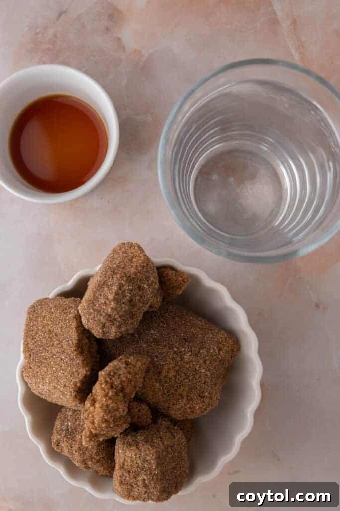 Various ingredients laid out for making the Starbucks brown sugar syrup recipe, including brown sugar, vanilla, and cinnamon sticks.
