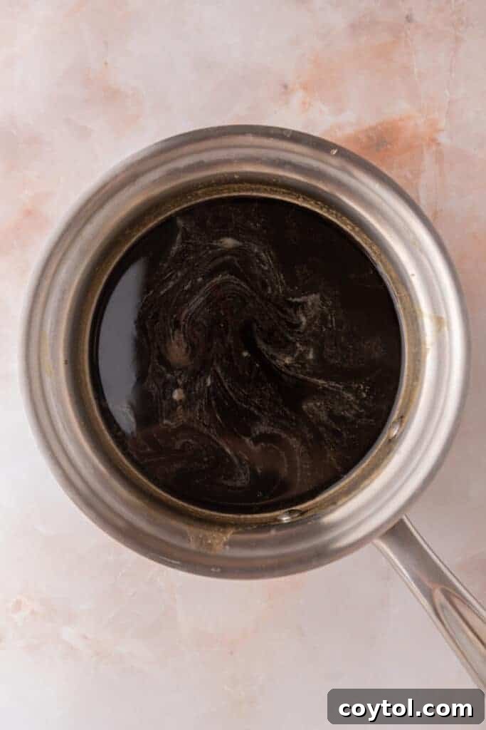 Mixed ingredients simmering gently in a saucepan, illustrating the dissolution process.