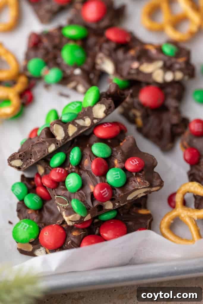 Christmas peanut pretzel M&M's bark chopped into festive squares on a white background