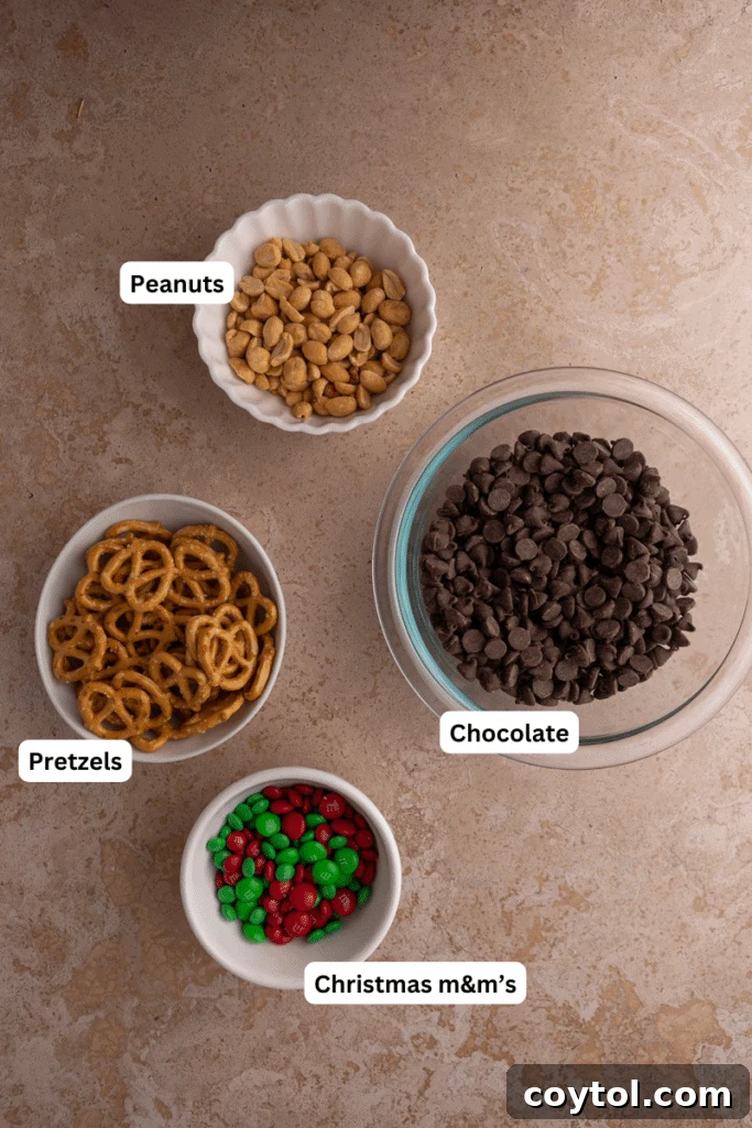 Ingredients laid out for Christmas peanut pretzel M&M's bark, including chocolate, pretzels, peanuts, and M&M's