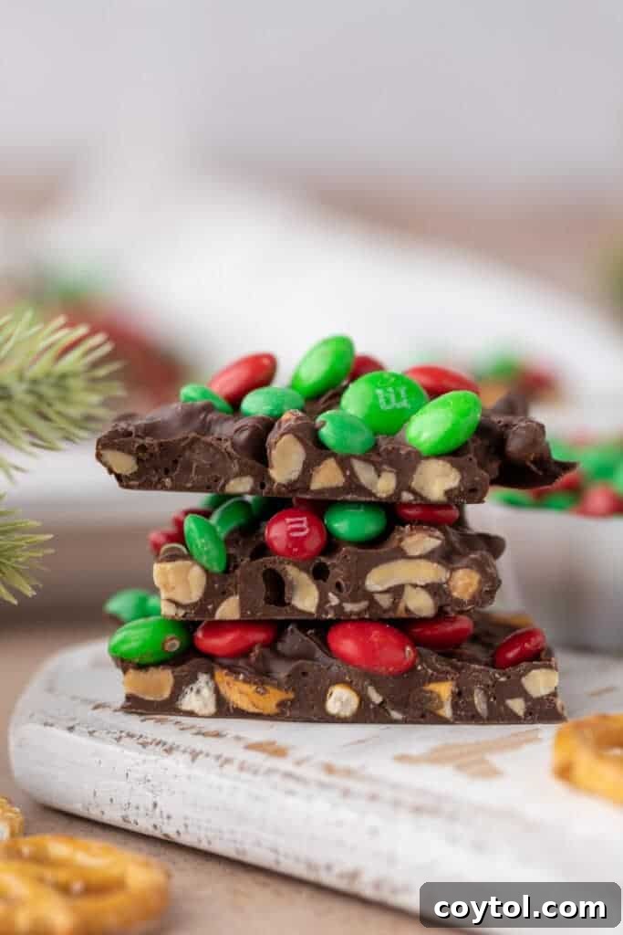 Stacked pieces of Christmas peanut pretzel M&M's bark, showcasing their delicious layers
