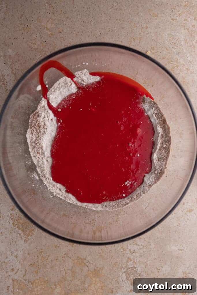 A bowl containing the unmixed dry ingredients, ready to be whisked together for the red velvet cupcakes.