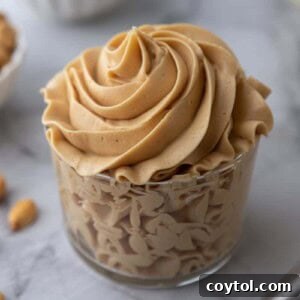 Creamy peanut butter frosting in a cup, ready for decoration.