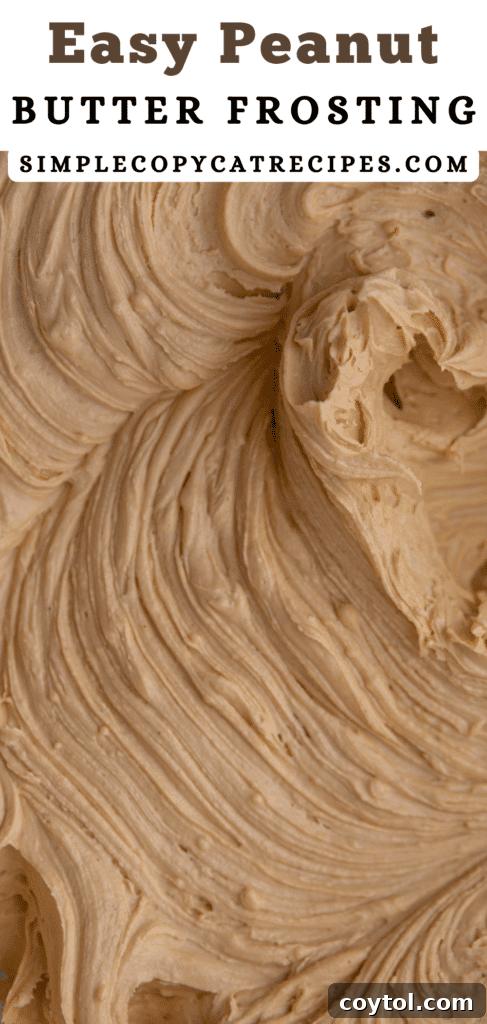 A bowl of creamy peanut butter frosting with a spatula, ready to be spread.