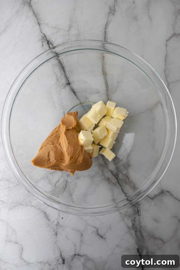 Unmixed ingredients for peanut butter frosting in a bowl, showing peanut butter and softened butter.
