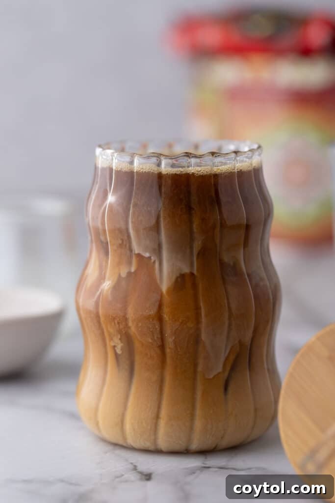 Effortless Homemade Brown Sugar Iced Coffee Indulgence 2 Delicious brown sugar iced coffee in a tall glass, garnished with a straw, viewed from the side.