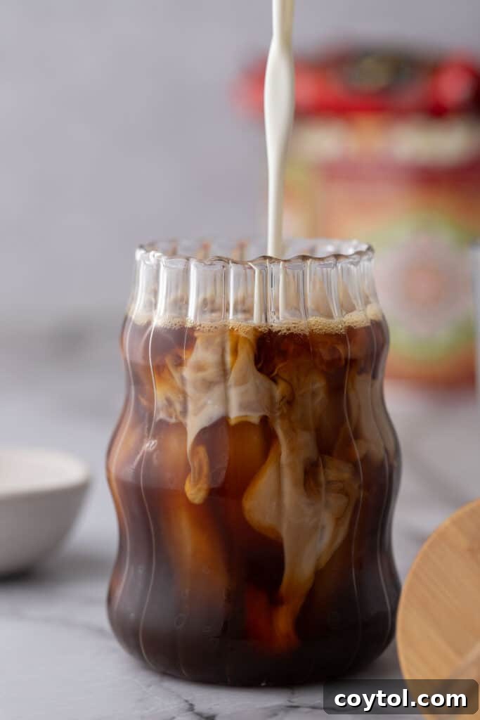 Effortless Homemade Brown Sugar Iced Coffee Indulgence 7 Creamy half-and-half being added to the brown sugar coffee over ice.
