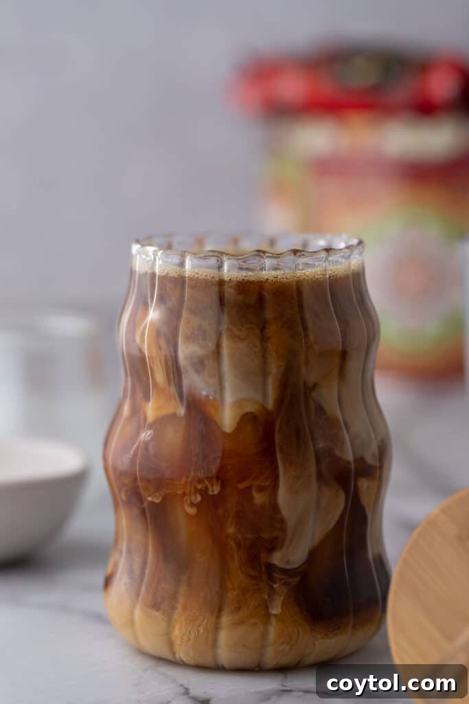 Effortless Homemade Brown Sugar Iced Coffee Indulgence 10 Side view of the brown sugar iced coffee in a clear glass, showing layers.