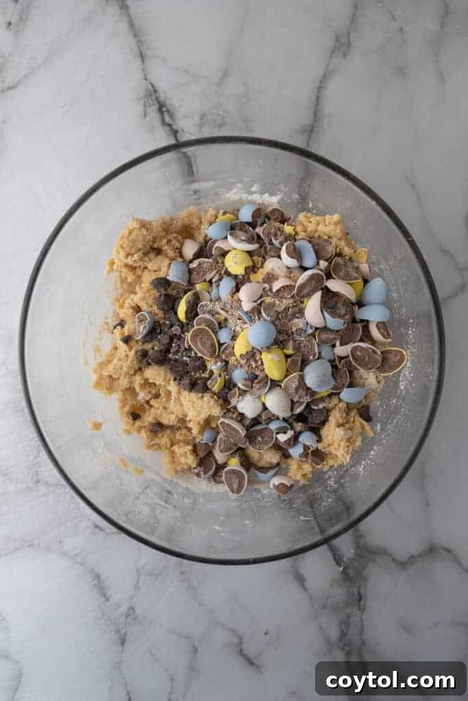 Irresistible Easter Mini Cadbury Egg Chocolate Chip Cookies 6 Mixed wet and dry ingredients in a bowl, forming cookie dough