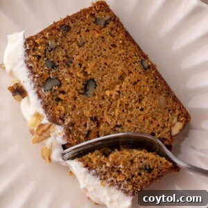 a slice of the carrot cake loaf cake recipe getting a piece taken out