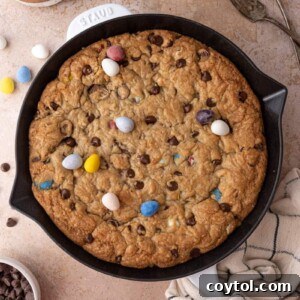 Close-up of a delicious Cadbury Mini Egg Skillet Cookie, rich with melted chocolate and colorful candies.