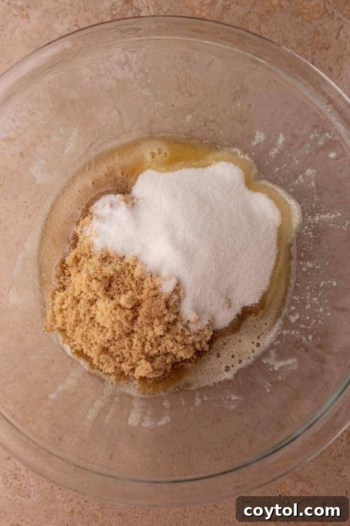 A large mixing bowl filled with unmixed dry ingredients, specifically flour, ready to be combined with wet ingredients.