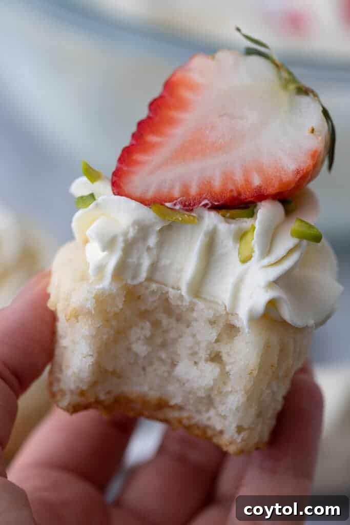 A beautifully frosted cupcake with mascarpone frosting, topped with a fresh strawberry, ready to be served