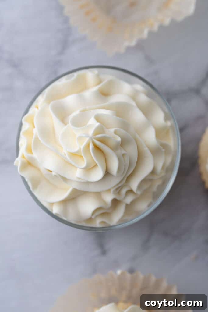 An overhead shot of the mascarpone cake frosting recipe in a glass cup, showing its inviting texture
