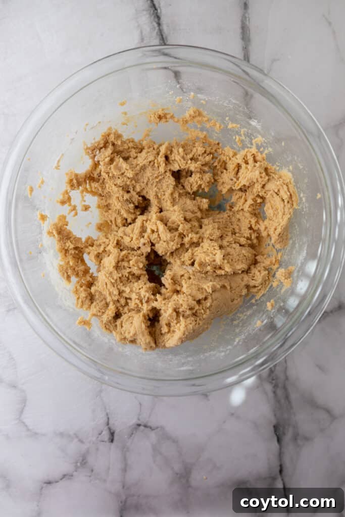 Mixed blondie batter in a bowl, ready for the pan.