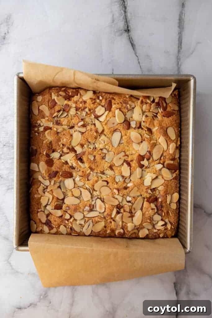 Fully baked almond croissant blondies in a pan, golden brown and ready to cool.