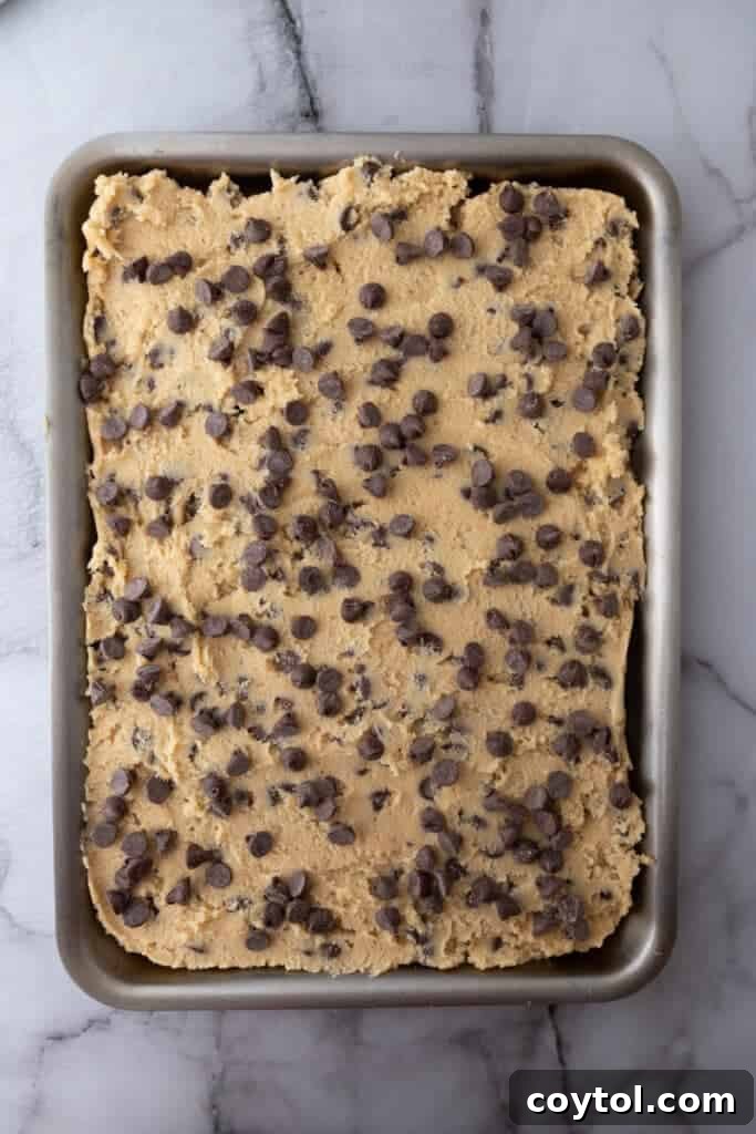 The Ultimate Soft and Chewy Nestle Toll House Cookie Bars 8 Cookie dough spread evenly in a baking sheet
