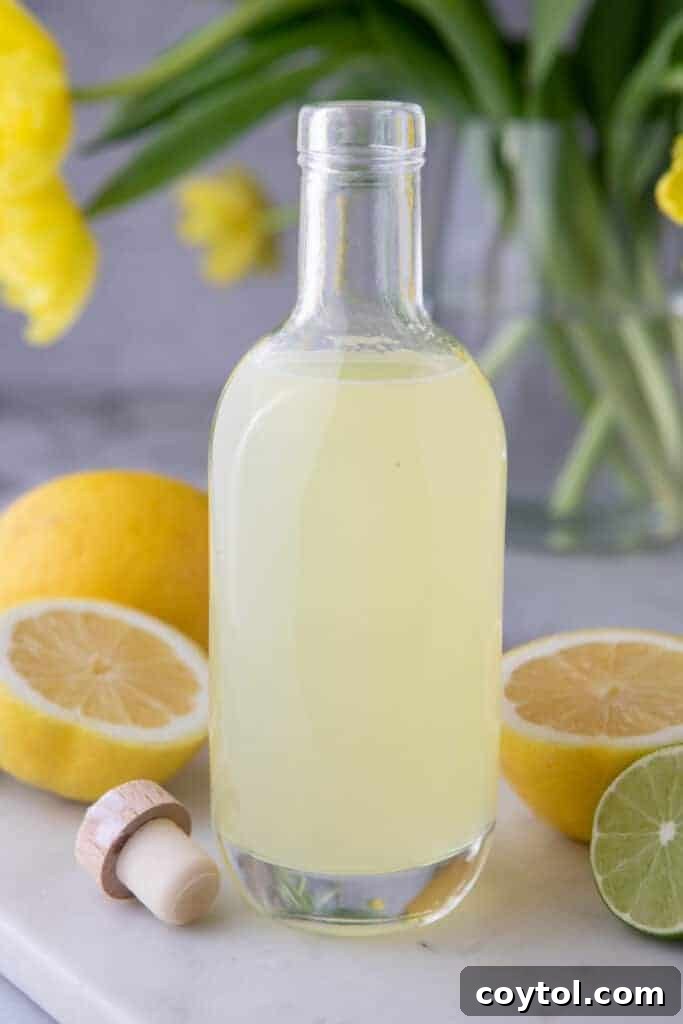 Easy Homemade Lemon Sour Mix Recipe 6 A close-up side view of homemade lemon sour mix in a clear glass bottle.