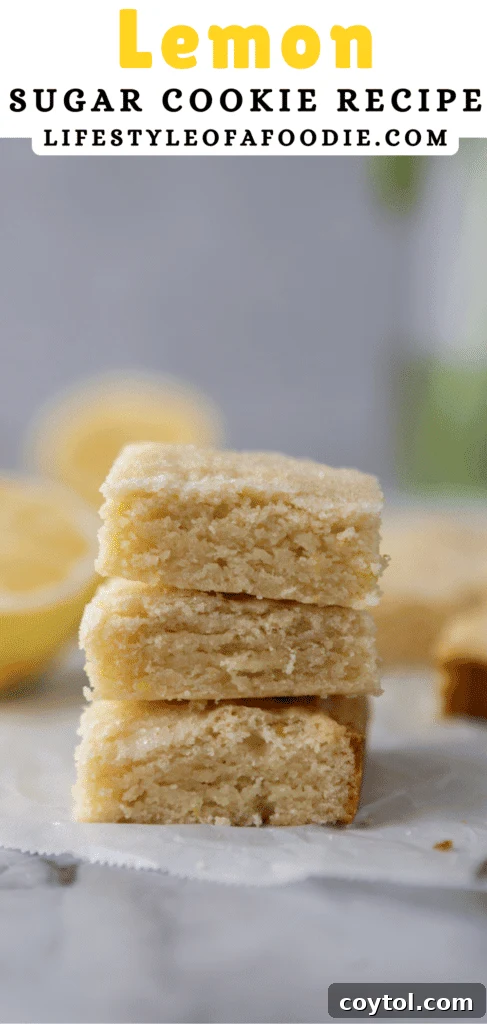 A stack of golden lemon sugar cookie bars with a light dusting of powdered sugar, hinting at their sweetness