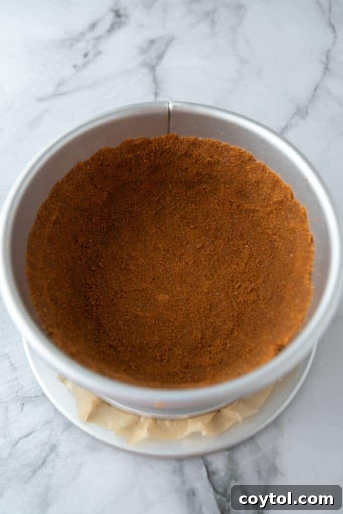 Biscoff cookie crust pressed into a springform pan