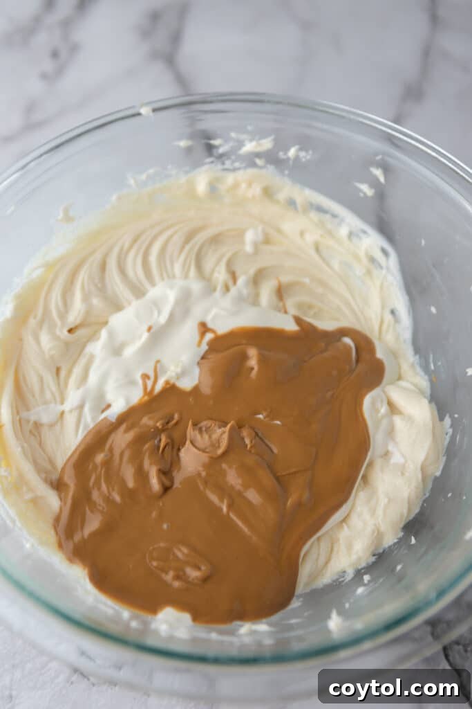 Cream cheese and sugar in a mixing bowl for cheesecake filling