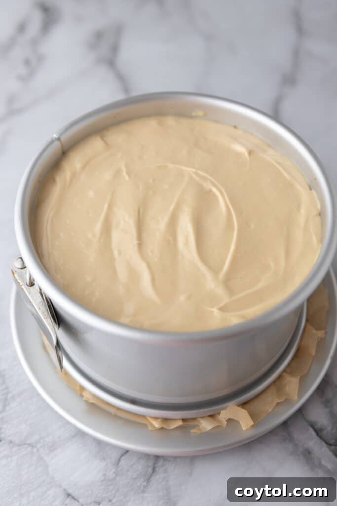 Smooth cheesecake batter poured over the Biscoff crust in the pan