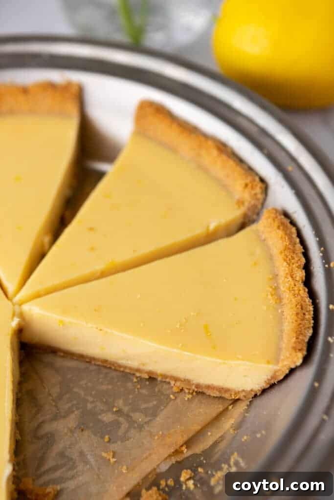 Several slices of lemon pie with graham cracker crust neatly arranged in the pie pan, ready for serving.