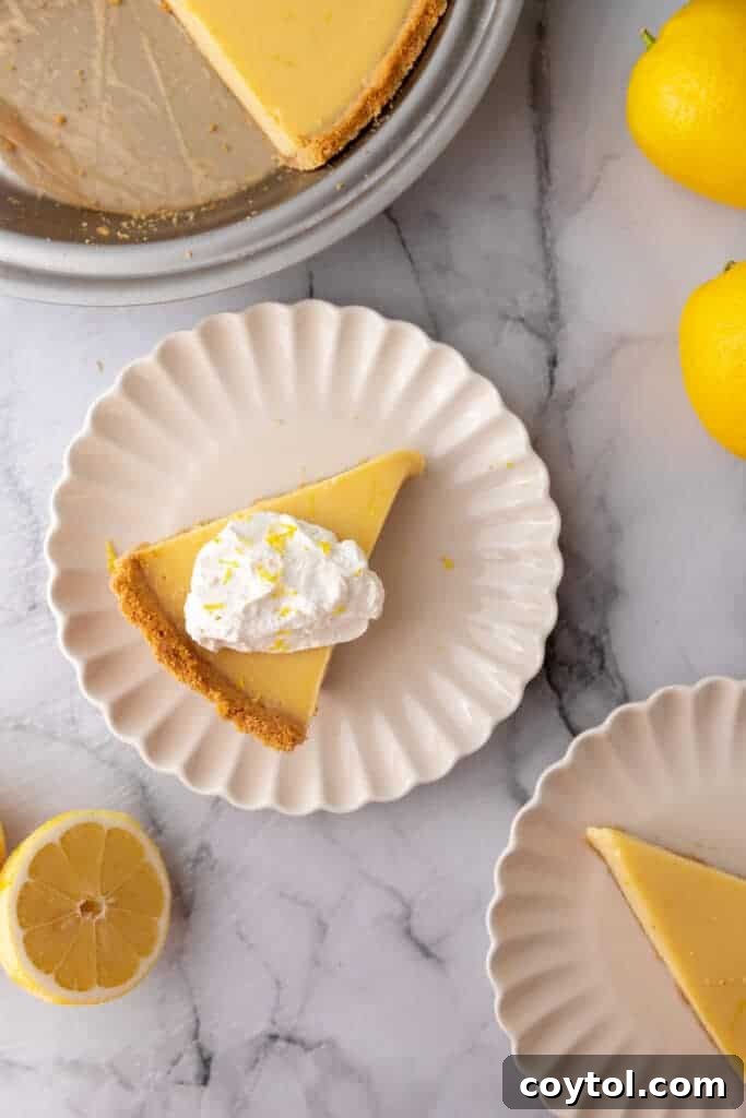 Individual slices of lemon pie with graham cracker crust on separate plates, garnished with whipped cream.