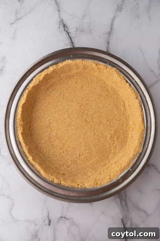 A perfectly baked graham cracker crust in a pie pan, golden brown and ready for filling.