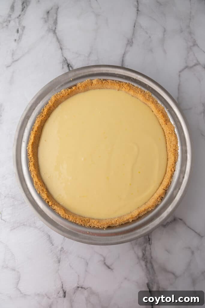 The unbaked lemon pie filling poured into the graham cracker crust, ready for the oven.