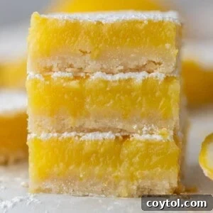 Three golden-yellow lemon bars stacked delicately, showcasing their powdery sugar dusting and thick, zesty filling over a shortbread crust.
