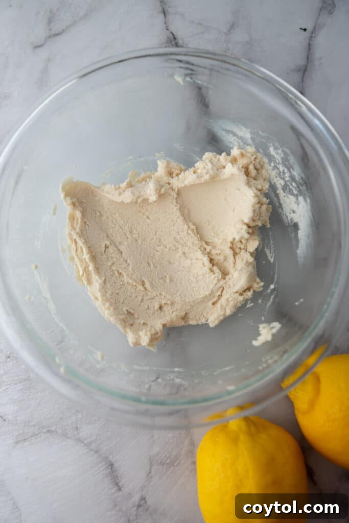 Creamed butter and powdered sugar for the shortbread crust in a bowl.