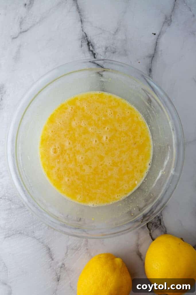 Smooth, whisked lemon filling mixture in a bowl, ready to be poured.